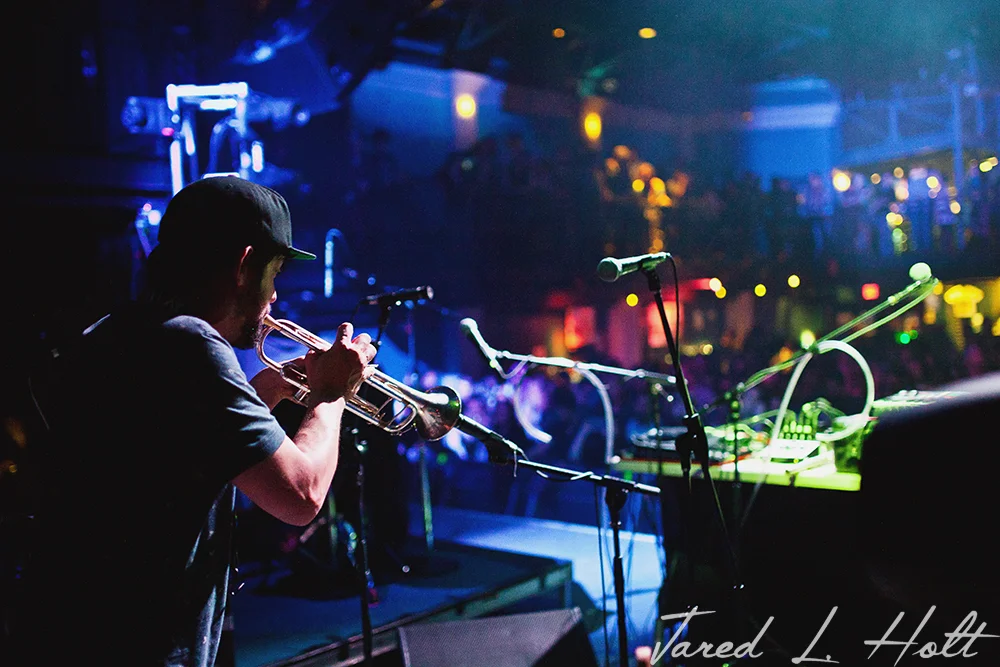 Russ Liquid plays trumpet during his opening set.