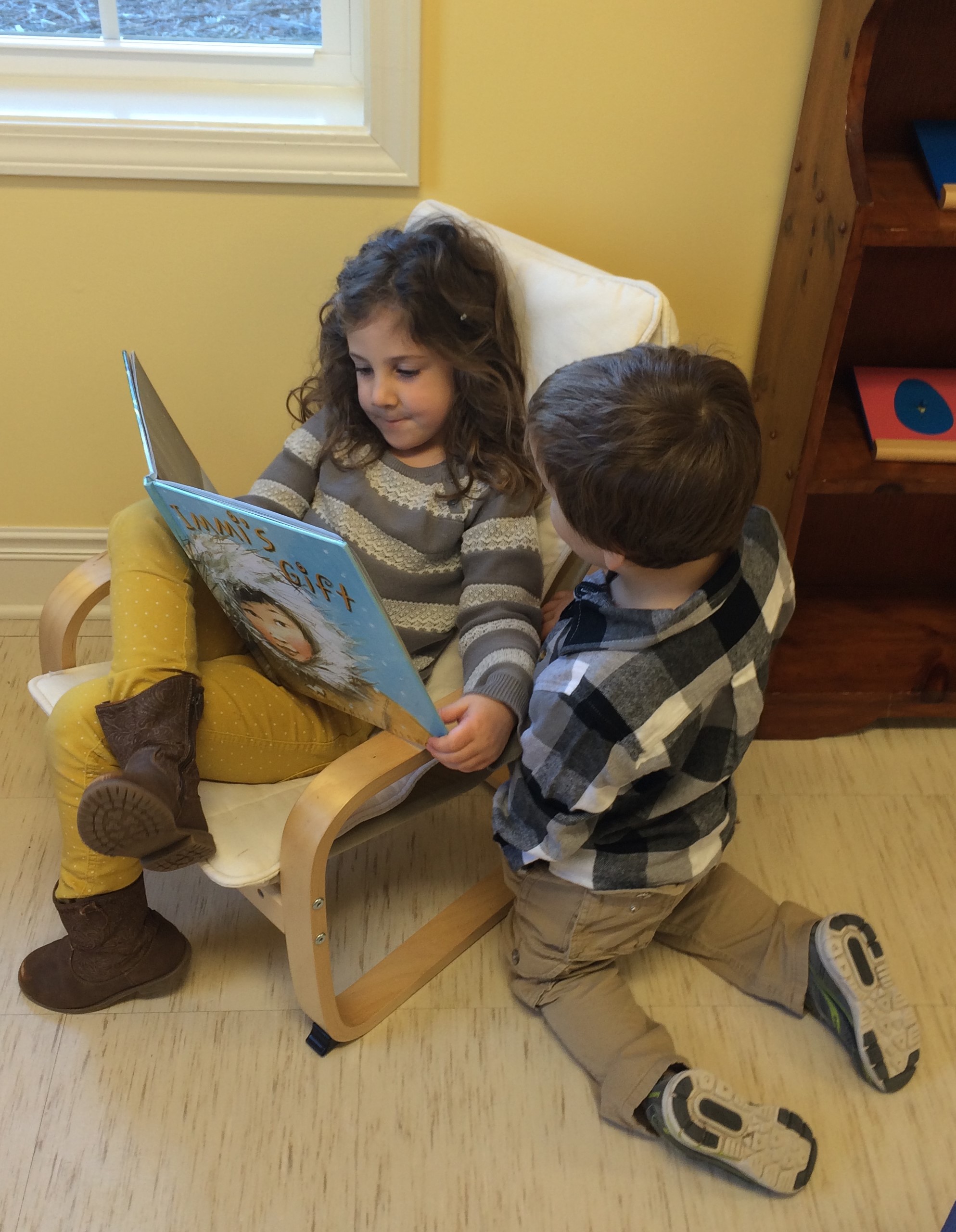 Reading and looking at the books in the library. Here a brother and sister enjoy a book together.