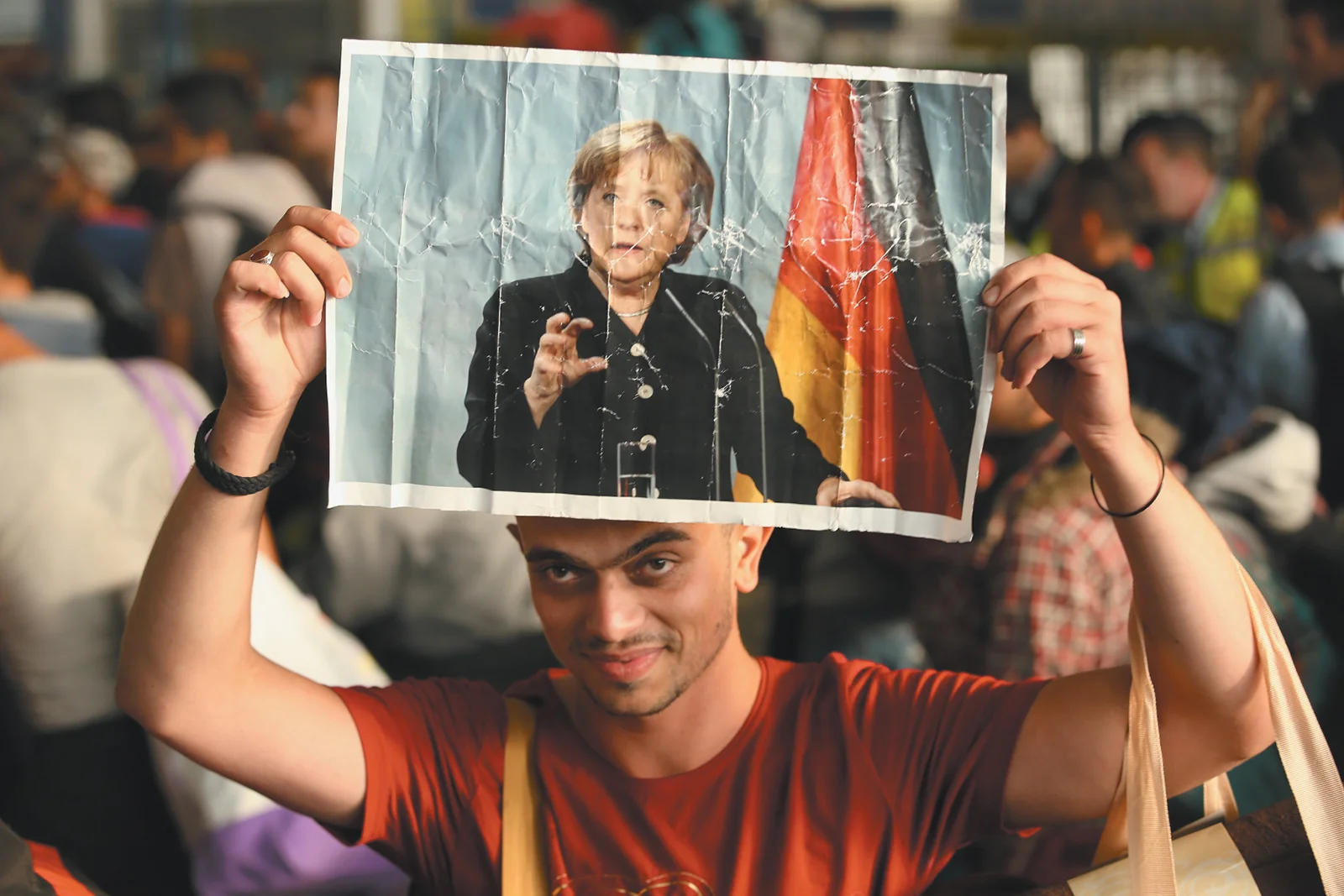 Un réfugié syrien tenant une photo de la chancelière allemande Angela Merkel lors de son arrivée à Munich avec des centaines d’autres migrants en provenance de Hongrie, en septembre 2015. Sean Gallup/Getty Images