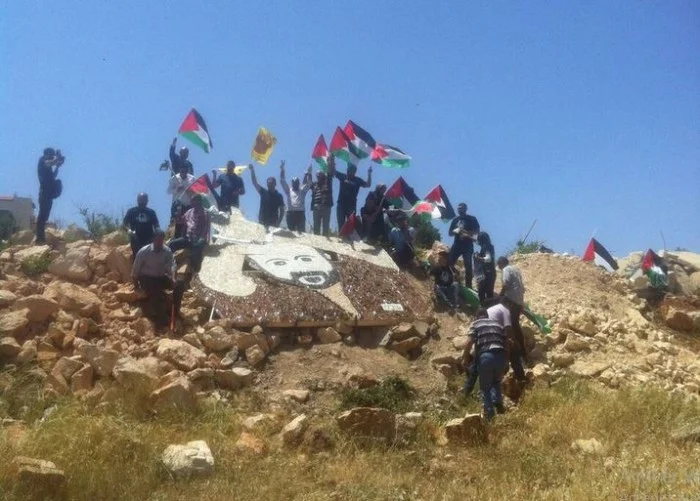 Des Palestiniens élèvent une fresque murale faite de tessons de verre représentant Marouane Barghouti près de la colonie illégale de Bet El.&nbsp;Photo@MariamBarghouti