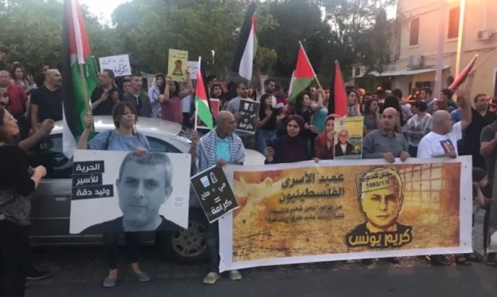 Manifestation de soutien à la grève de la faim à Haïfa.&nbsp;À gauche : Walid Dakka, Palestinien de 1948, né en 1961 à&nbsp;Baqa al-Gharbiya,&nbsp;condamné en 1986 à la prison à vie.&nbsp;Au centre : "Eau + sel = dignité".&nbsp;À droite Karim Younes…
