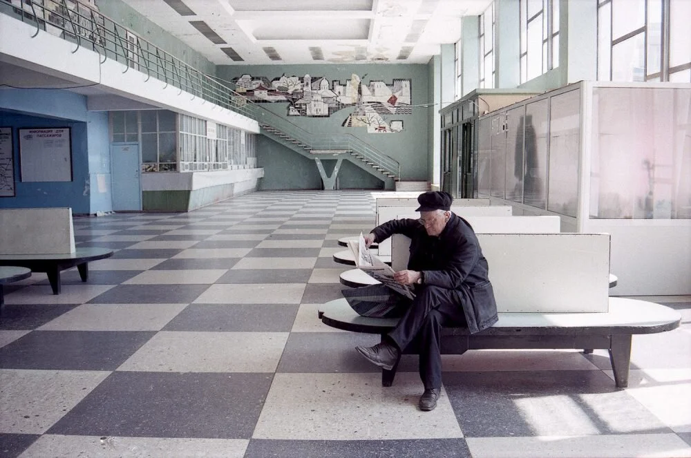 Un homme lit un journal dans le bâtiment de la gare routière de la ville de Bender. Bendery, Transnistrie, Moldavie, 2017.