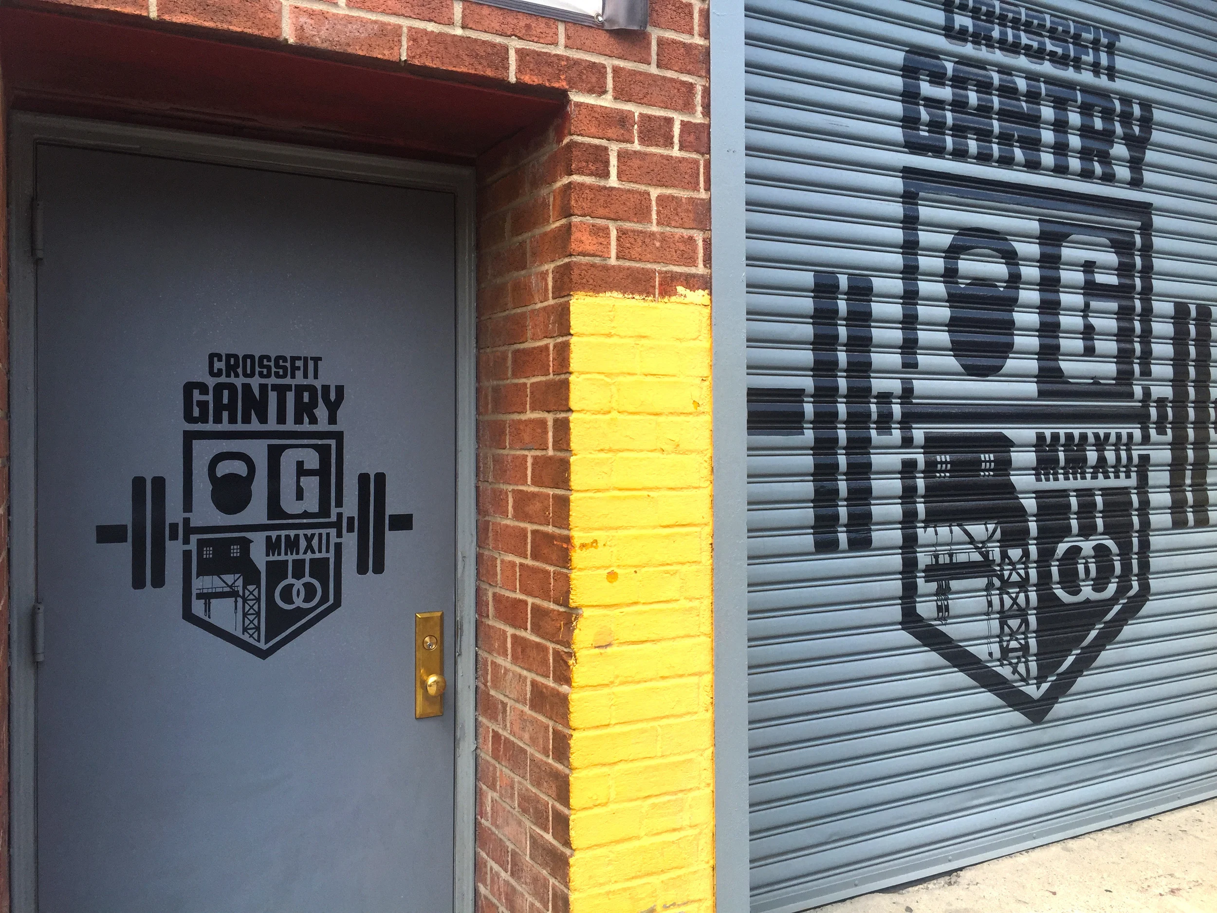 Signs on metal door and rollgate at CrossFit Gantry in Long Island City, Queens, NY.