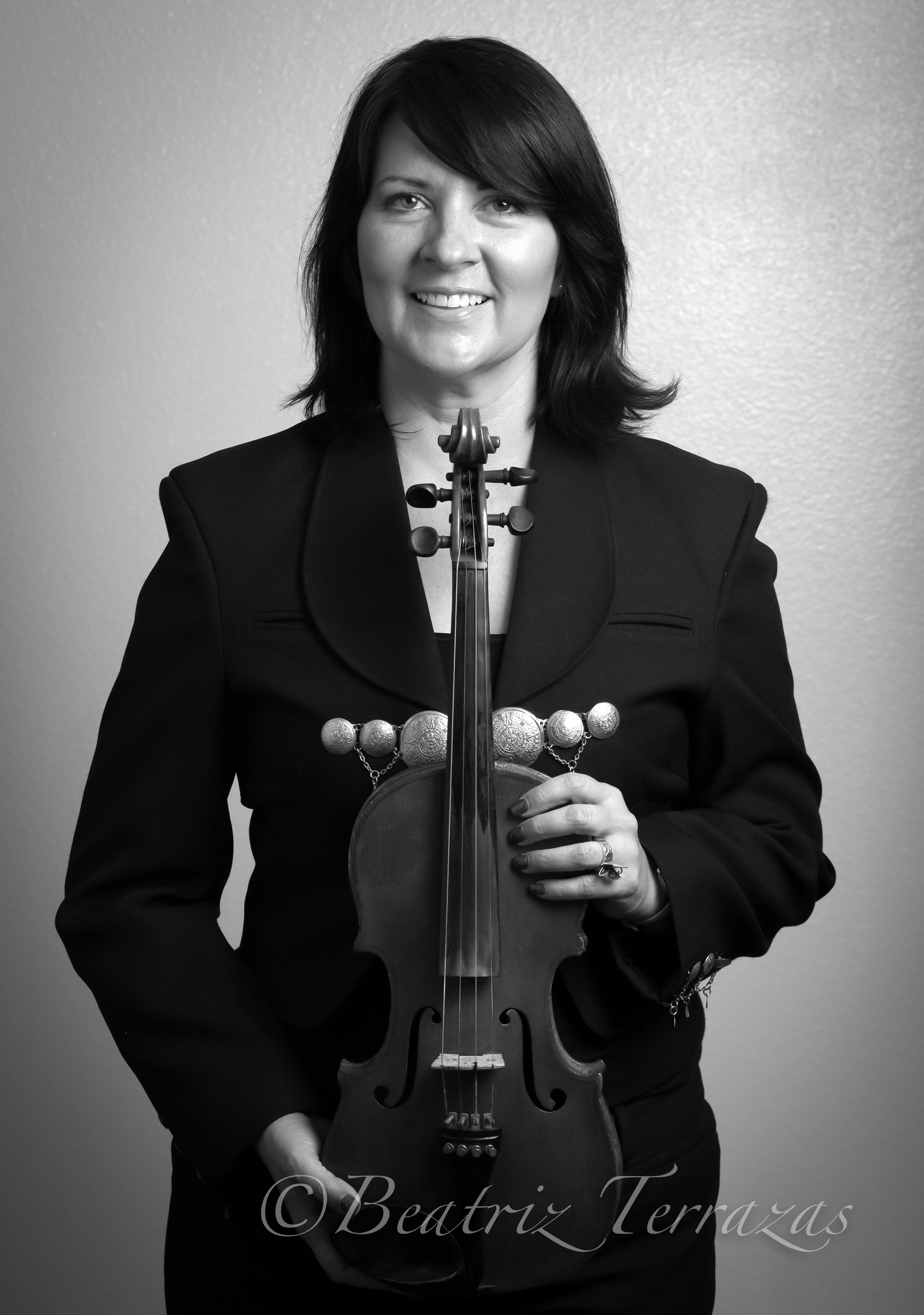 Susie Olmos-Soto comes from a large mariachi family. This is one of the three violins she owns and the last one with which she performed. She's also wearing the silver-studded charro jacket that's part of her mariachi outfit. 