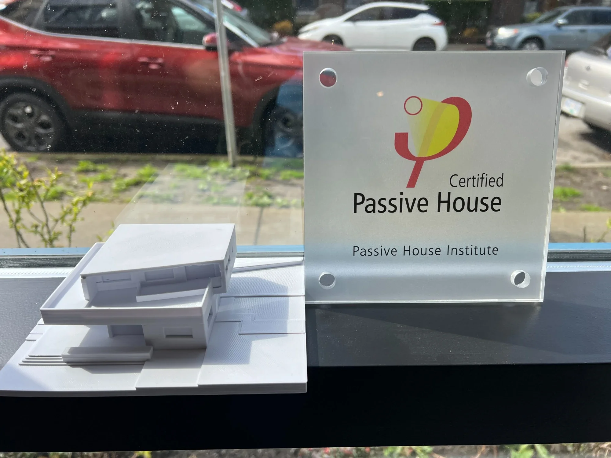 PHI passive house plaque for the Dalbebright passive house in burnaby, along with the 3d printed model of the house, in the window of Lanefab's office