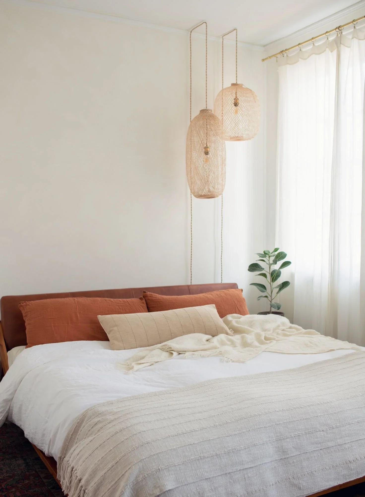 modern bedroom with rattan bamboo lanterns, linen duvet and linen curtains with textured roman clay walls