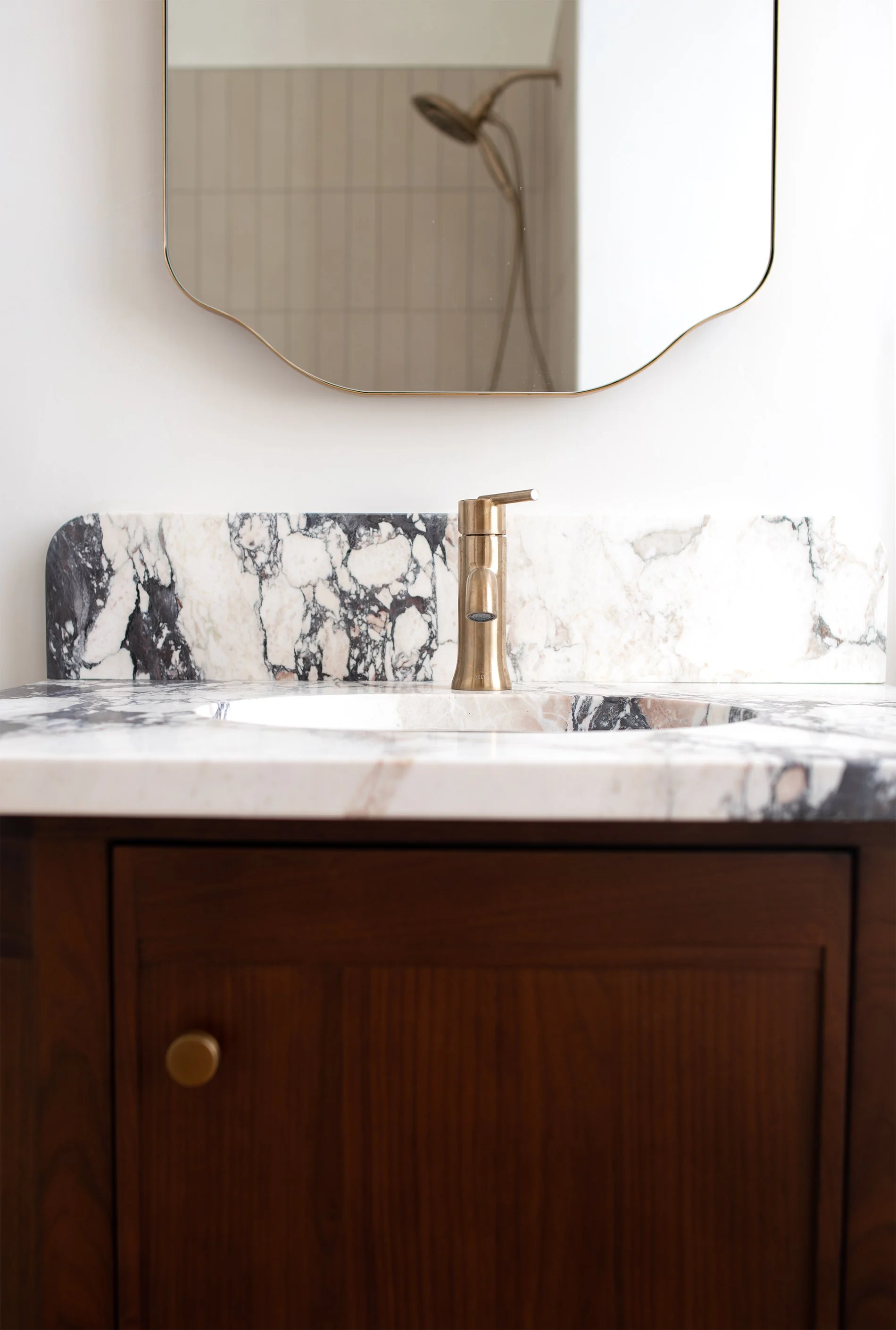 Bathroom remodel showing brass fixtures and calacatta viola marble vanity in historic Richmond VA home, walnut vanity
