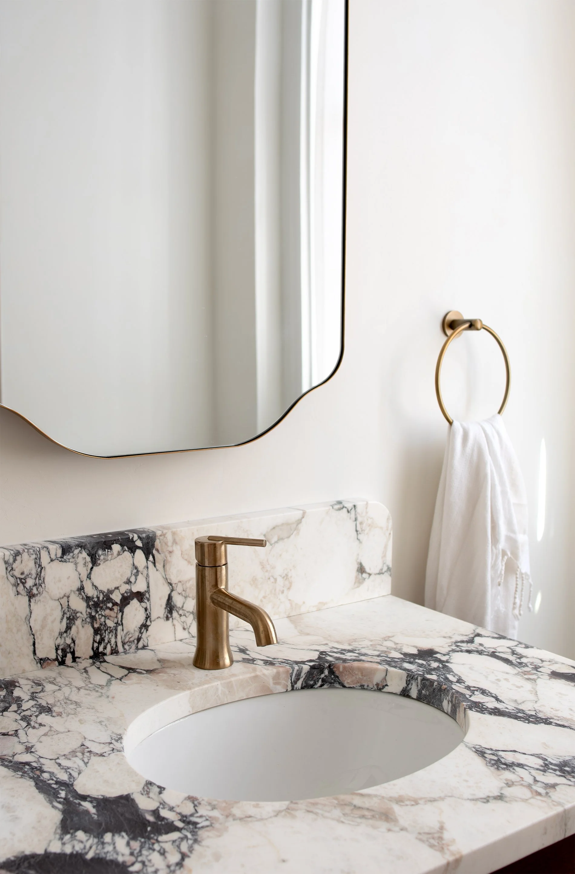 Bathroom remodel showing brass fixtures and calacatta viola marble vanity in historic Richmond VA home