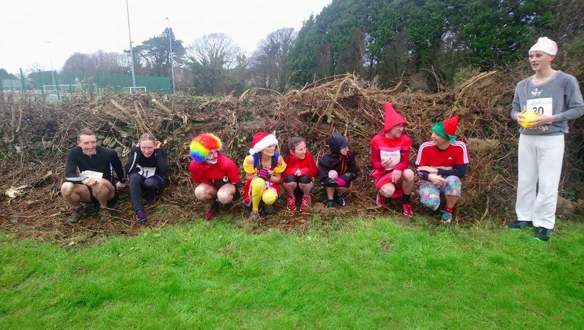 Runners take shelter from the bracing wind before the start!