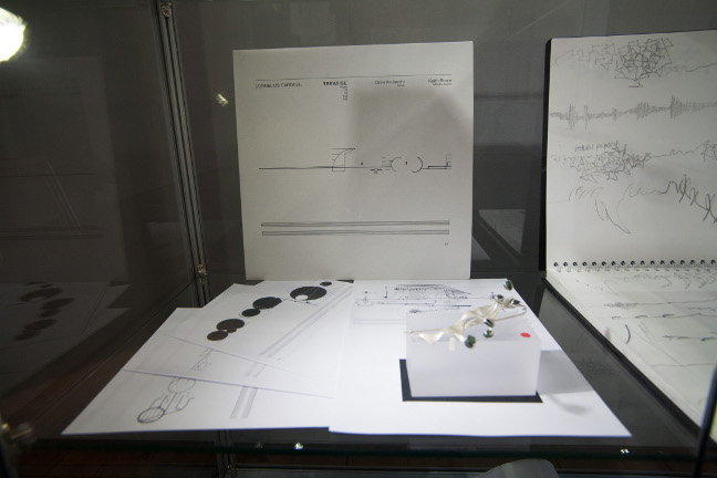 Process material, sketches, silver brooch with rough emeralds work in process