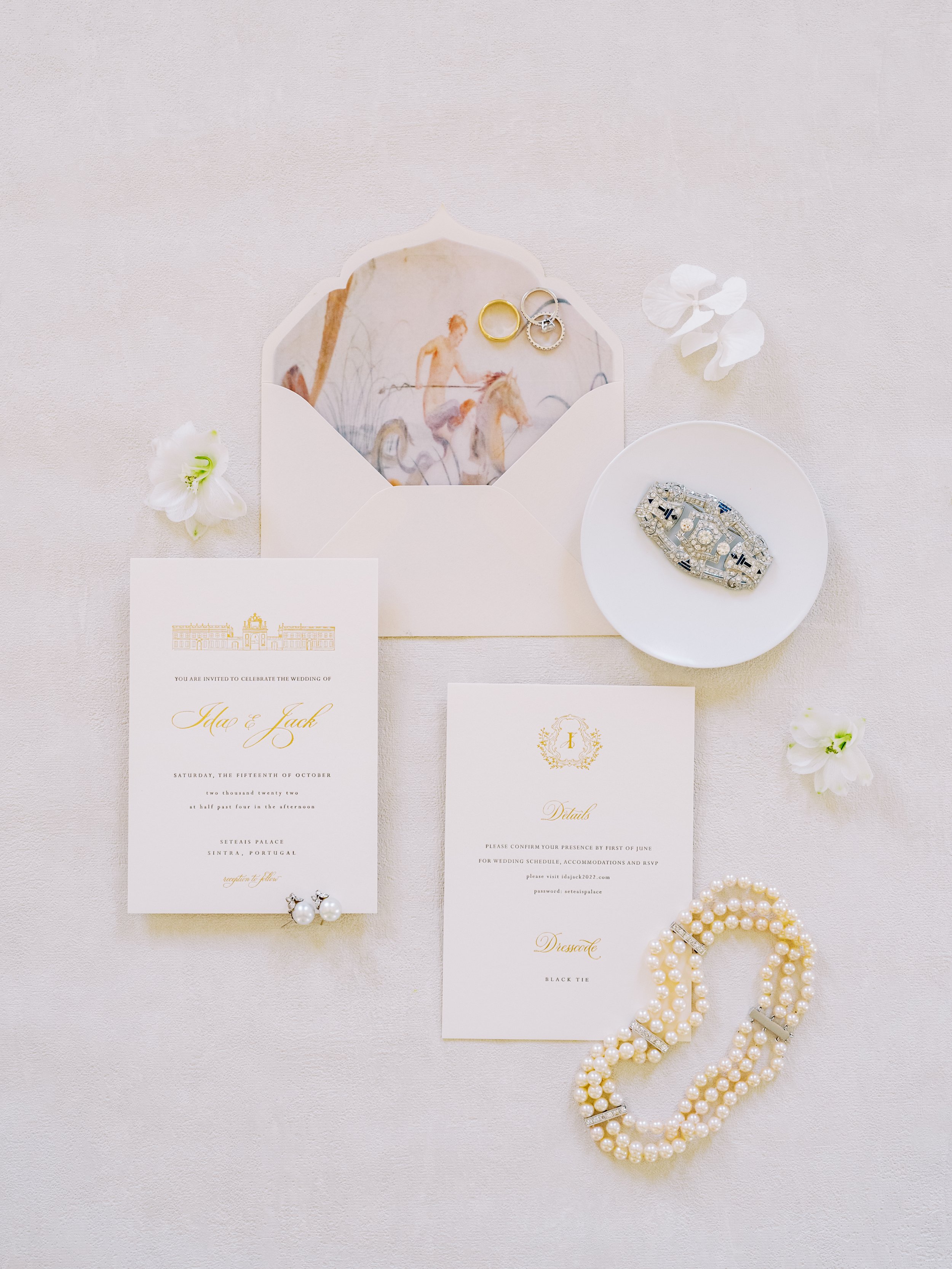 A flat lay with elegant style showing the wedding stationary and jewellary