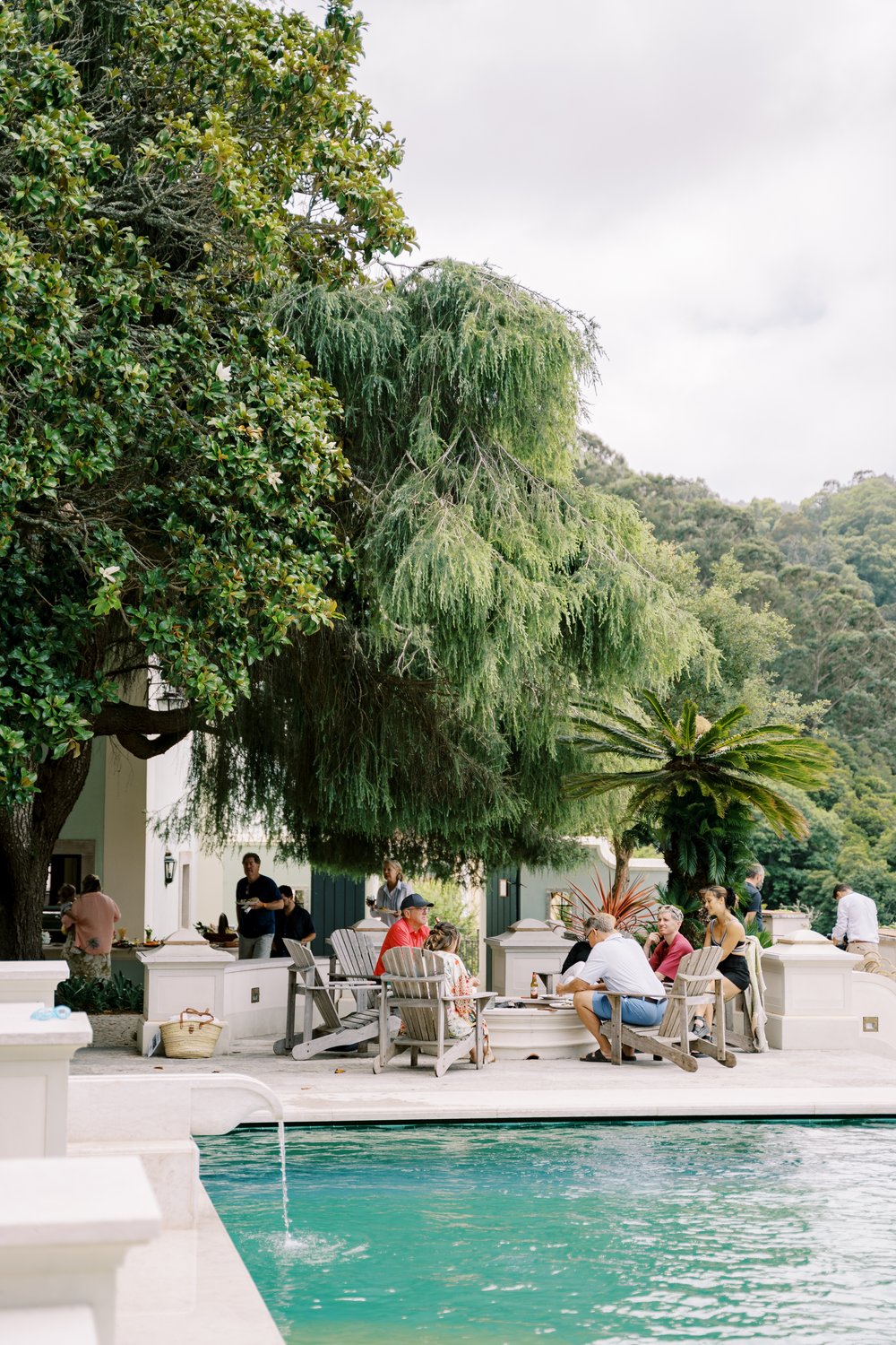 Guests enjoying the beautidul weather and chatting in the morning of the wedding next to the pool oat Quinta da Bela Vista