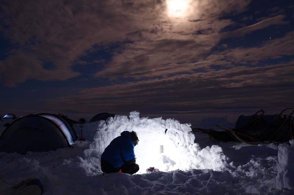 It's close to midnight by the time most Fjällräven Polar participants have an opportunity to boil water for dinner. To shelter us from Råstu's nasty wind, we construct walls out of blocks of snow. (Photo by Søren Hauris Larsen. All rights reserved.)