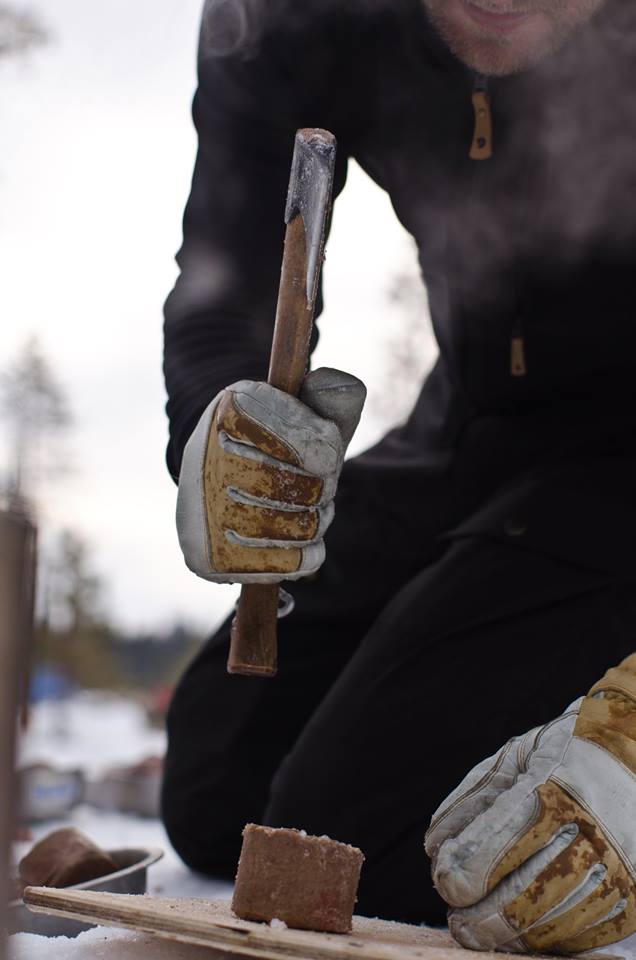 The logs of meat that the dogs eat, consisting mainly of tripe, are frozen solid by the time we arrive at camp. Before they are mixed with boiling water, they must be chopped into pieces with a wood-handled hatchet. (Photo by Søren Hauris Larsen. All rights reserved.)