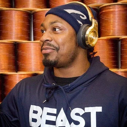 marshawn lynch facing to the left looking serious trying not to laugh but he's hot.jpg