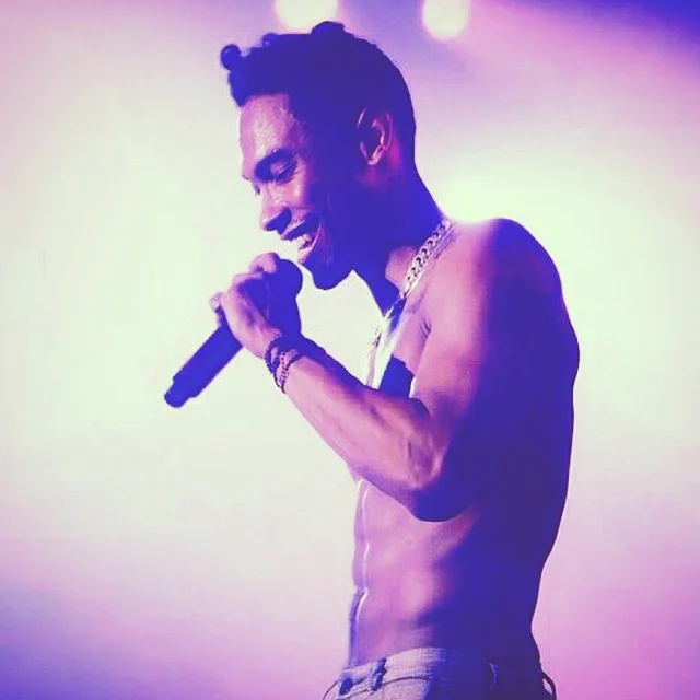Miguel looking SO hot with no shirt on and a microphone and a purple gradient.jpg