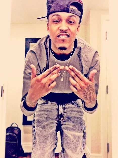 August Alsina with a bookbag in the background of a heavily edited picture.jpg