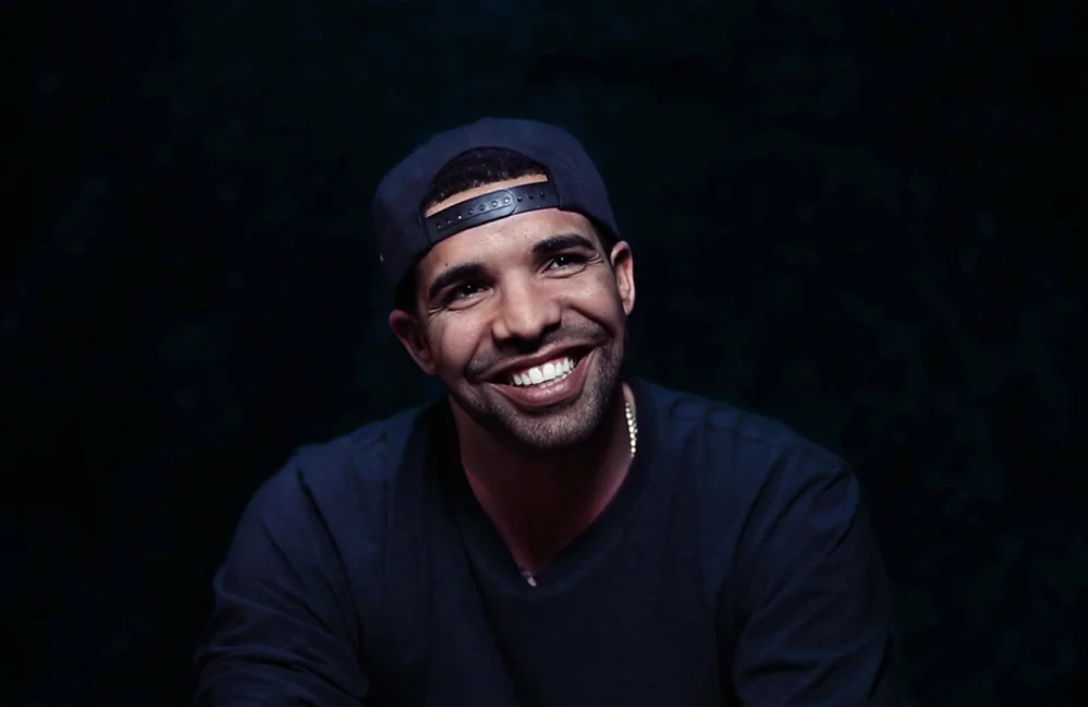Drake looking really hot and smiling on a black backdrop.jpg