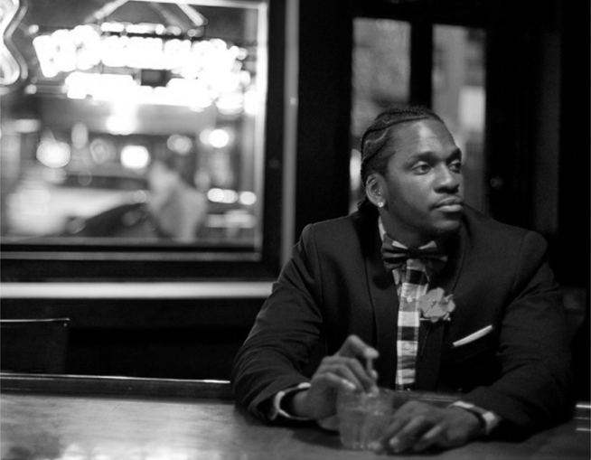 Pusha T looking really hot inside a bar with a drink while wearing plaid and a blazer.jpg