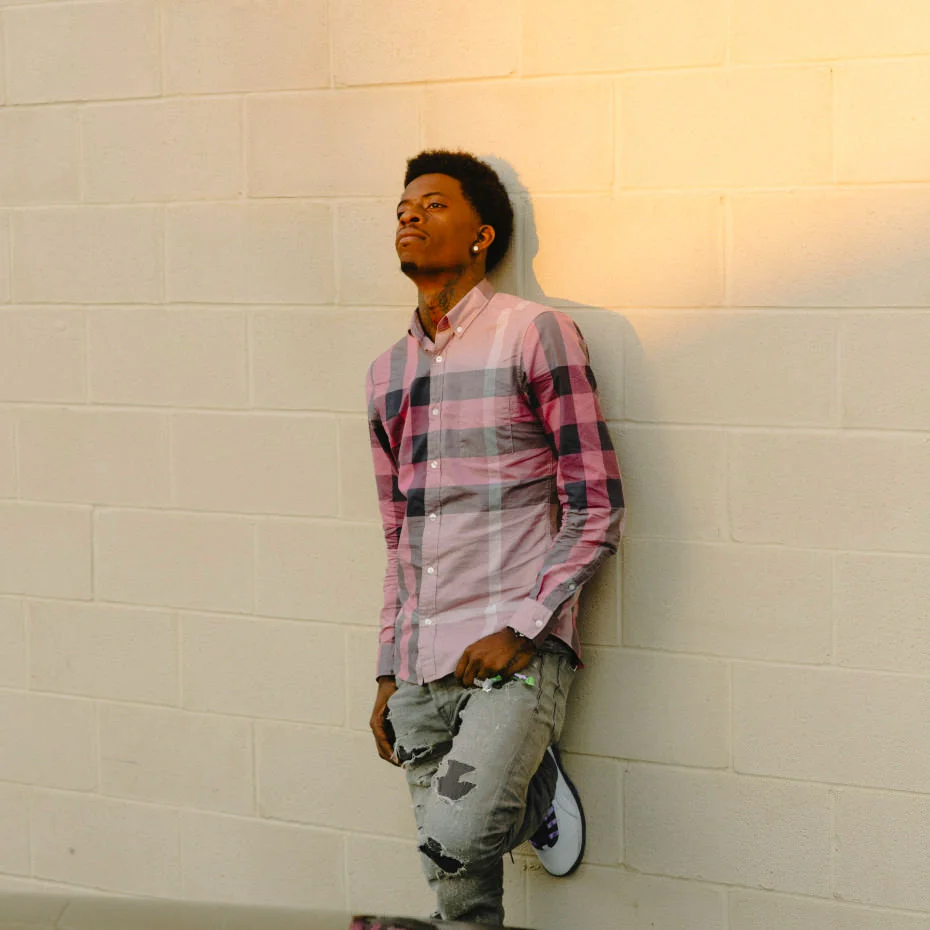 Rich Homie Quan looking stunning as he rests upon a painted cinderblock wall.jpg