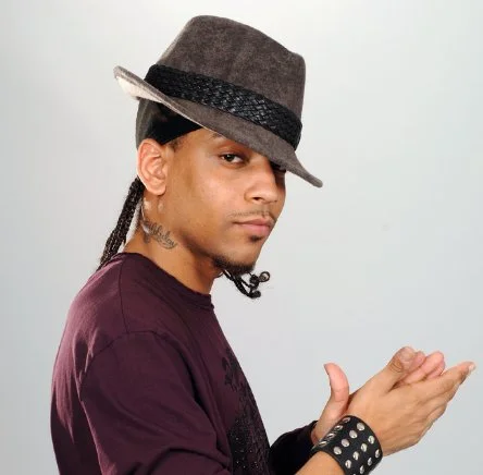 J. Holiday pulling off a fedora.jpg