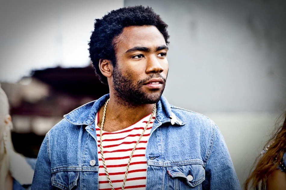 Childish Gambino wearing a denim jacket and a white and red striped shirt and looking hot.jpg