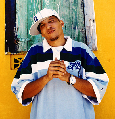 Rupee wearing a very large oversized polo shirt with a hat and a watch on.jpg