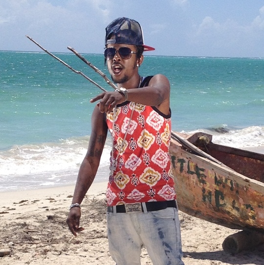 Popcaan wearing a tank top and looking hot on the beach in Jamaica.jpg
