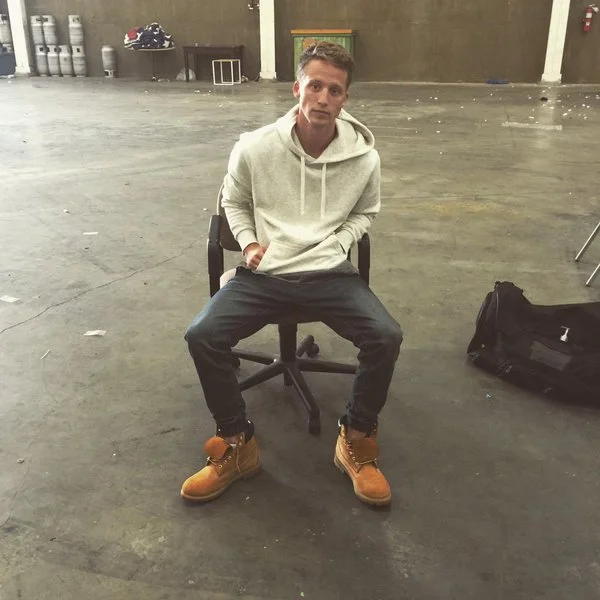 NF sitting in a chair in an empty warehouse.jpg