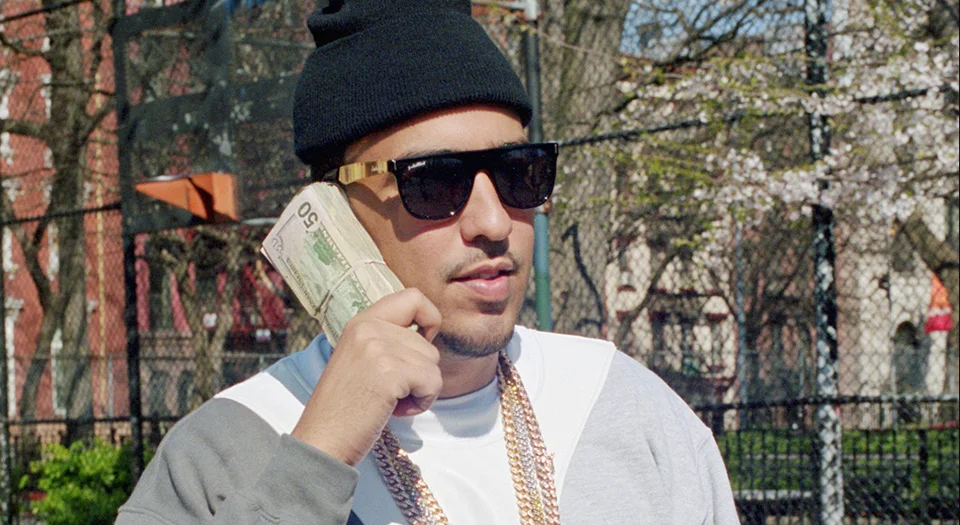 French Montana on the phone with a large sum of money.jpg