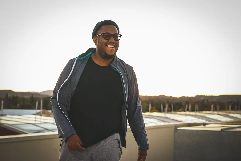 Guordan Banks wearing sweatpants and looking hot with his gorgeous smile on top of a building's roof.jpg