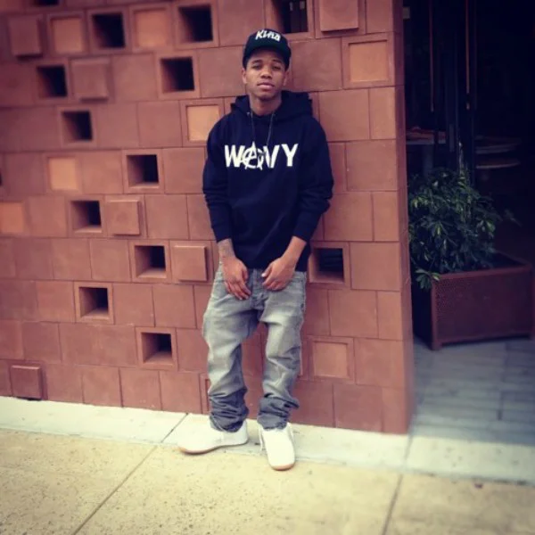 A$AP Ty Beats outside of a cool wall with holes in it as he looks hot.jpg