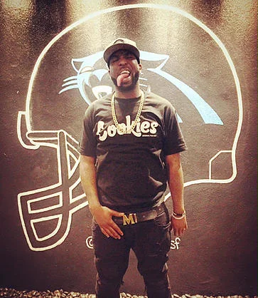 Luke Nasty and his huge tongue behind a graphic for the Carolina Panthers which suck bc Cam Newton is a huge baby.jpg