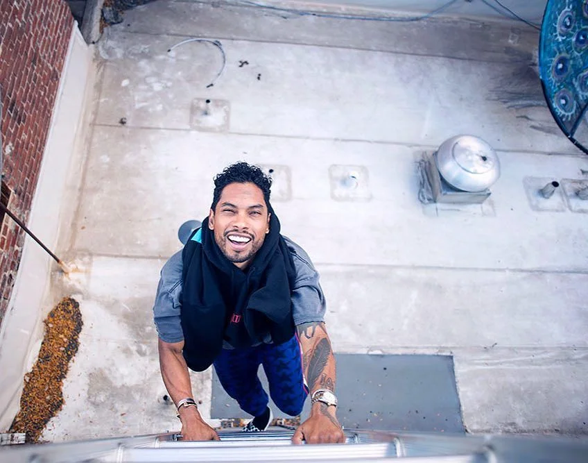 Miguel looking hot and climbing up a ladder on a rooftop.jpg