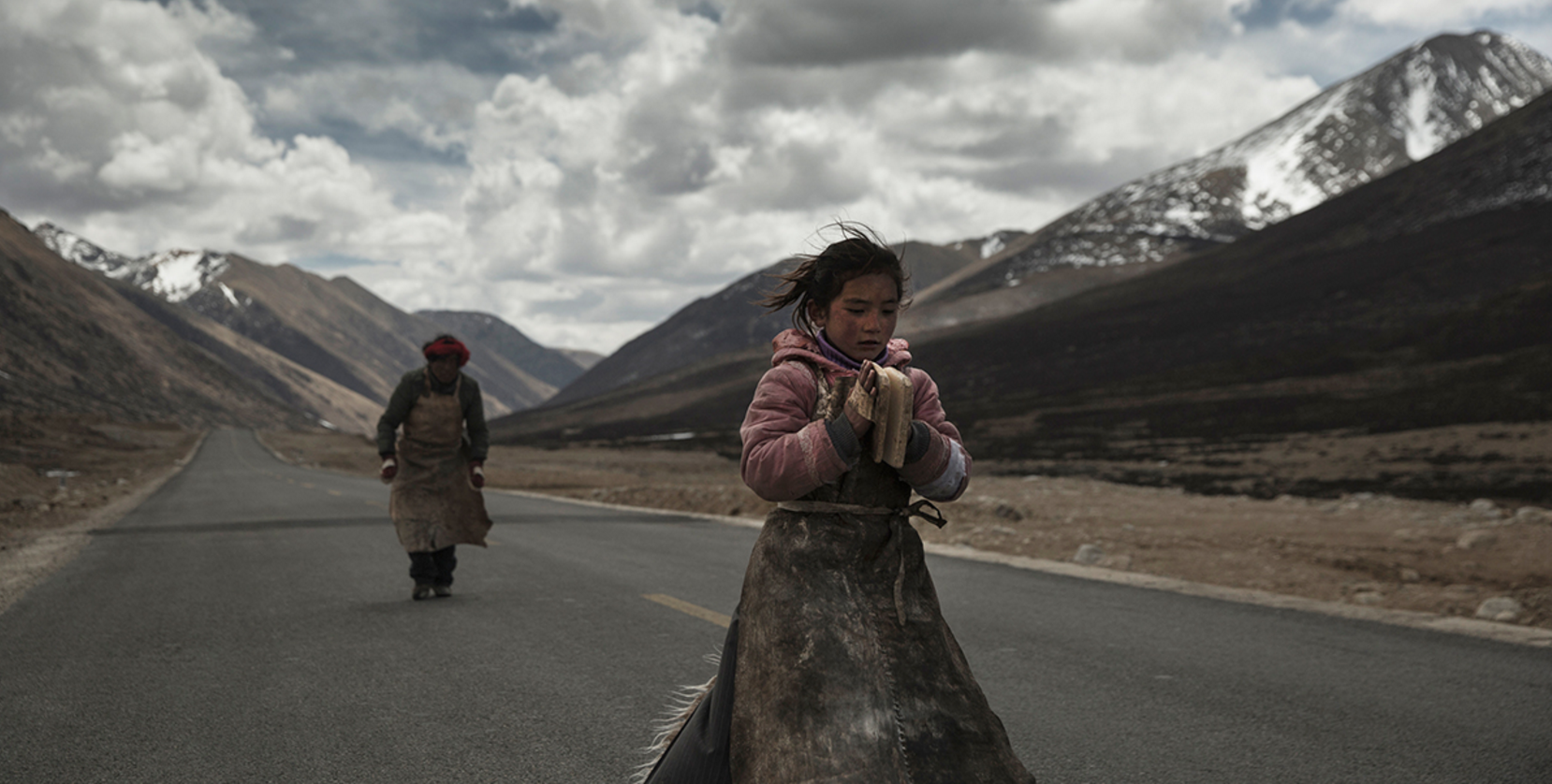 Pilgrims walk a Tibetan highway, prostrating themselves on the pavement at near intervals.