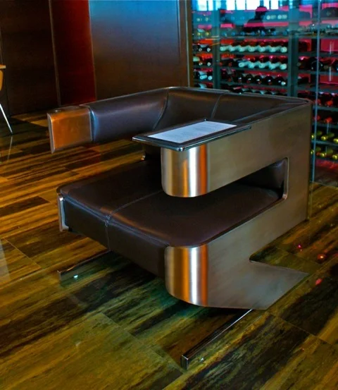 These Tronas chairs are bronze and leather with stainless tray tables.