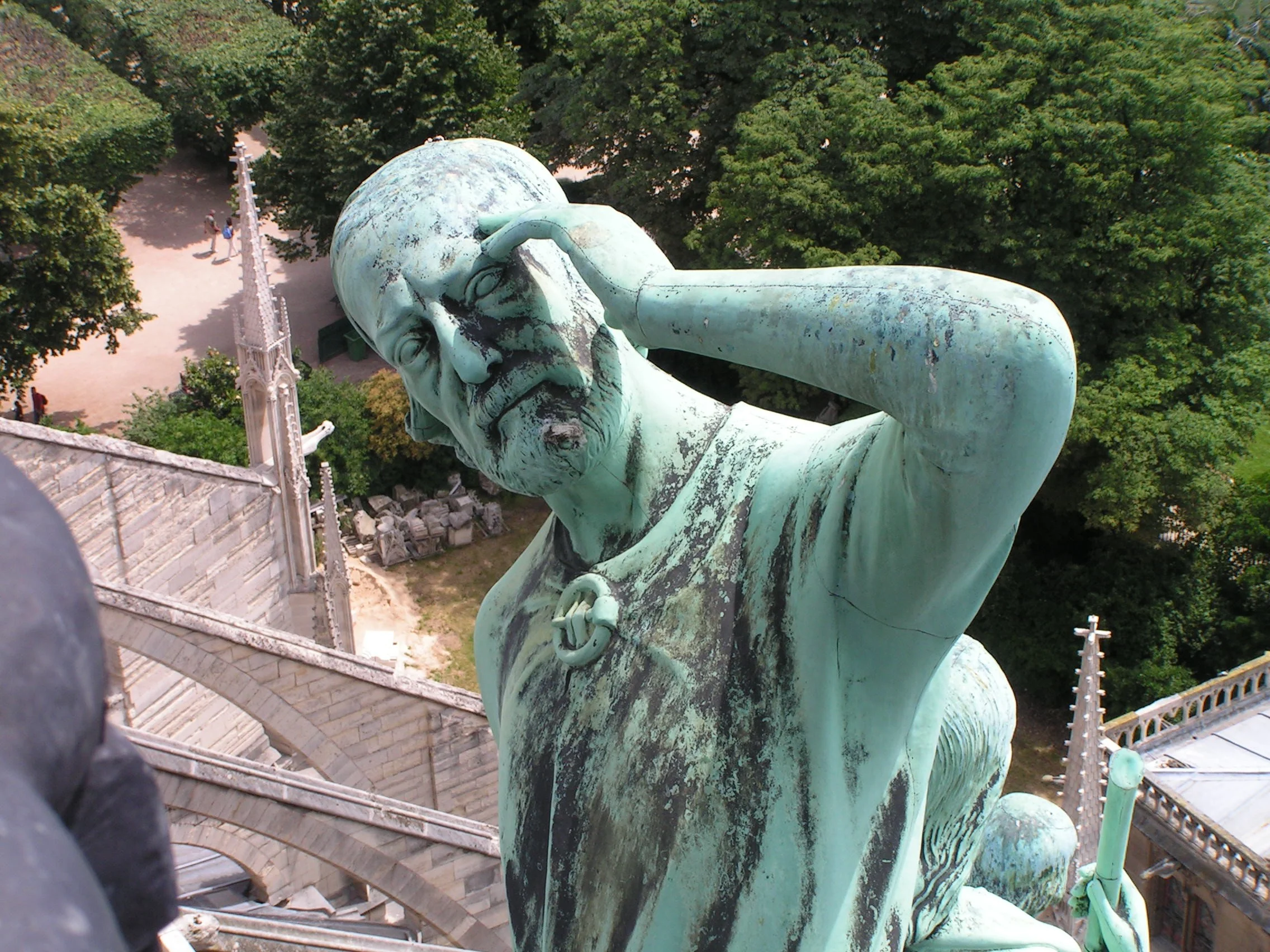 Voillet-Le-Duc (as St. Thomas) looks up at his tower while the other Apostles look back at the city.