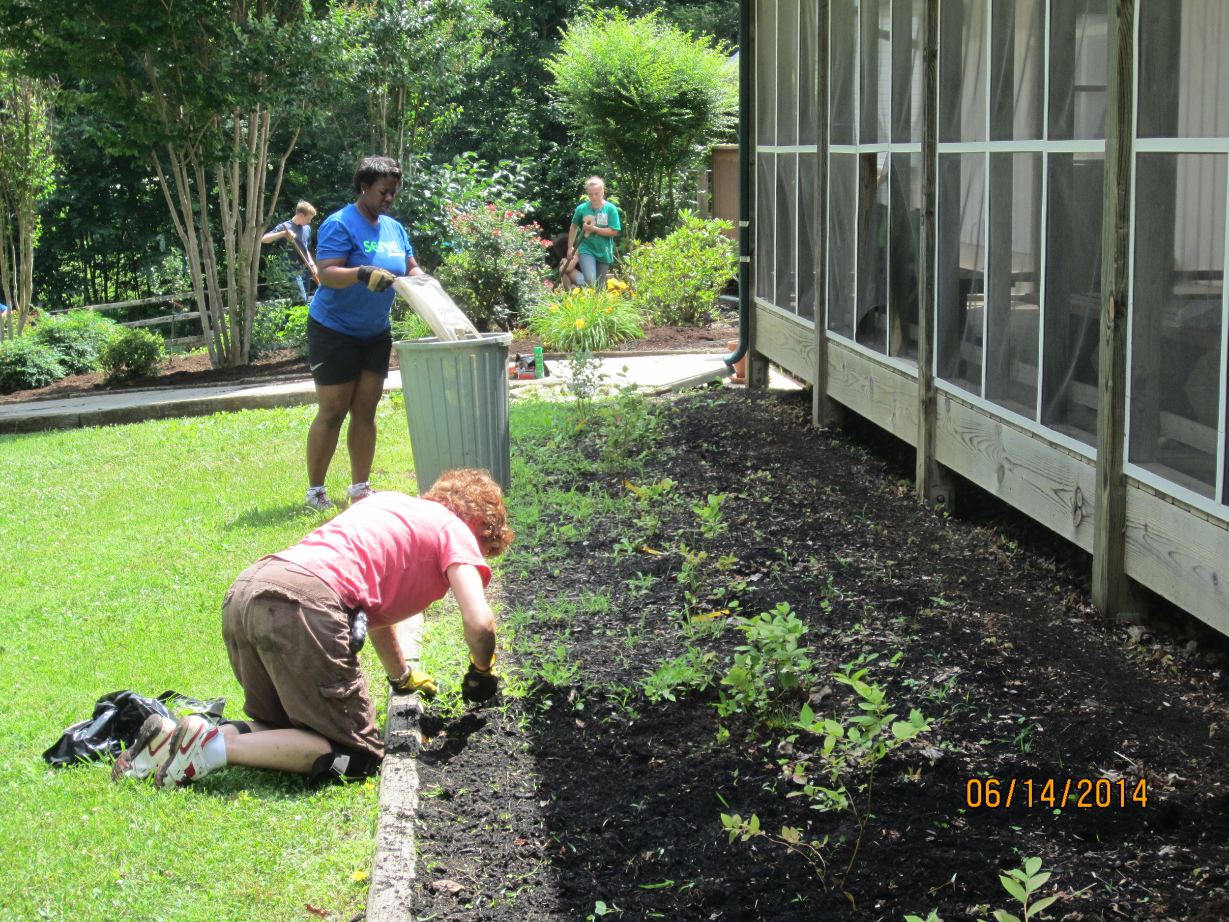 Nanci Scott, Demetria Utley, Zach and Allie Reid continue to prepare the Dining Hall beds for mulching.