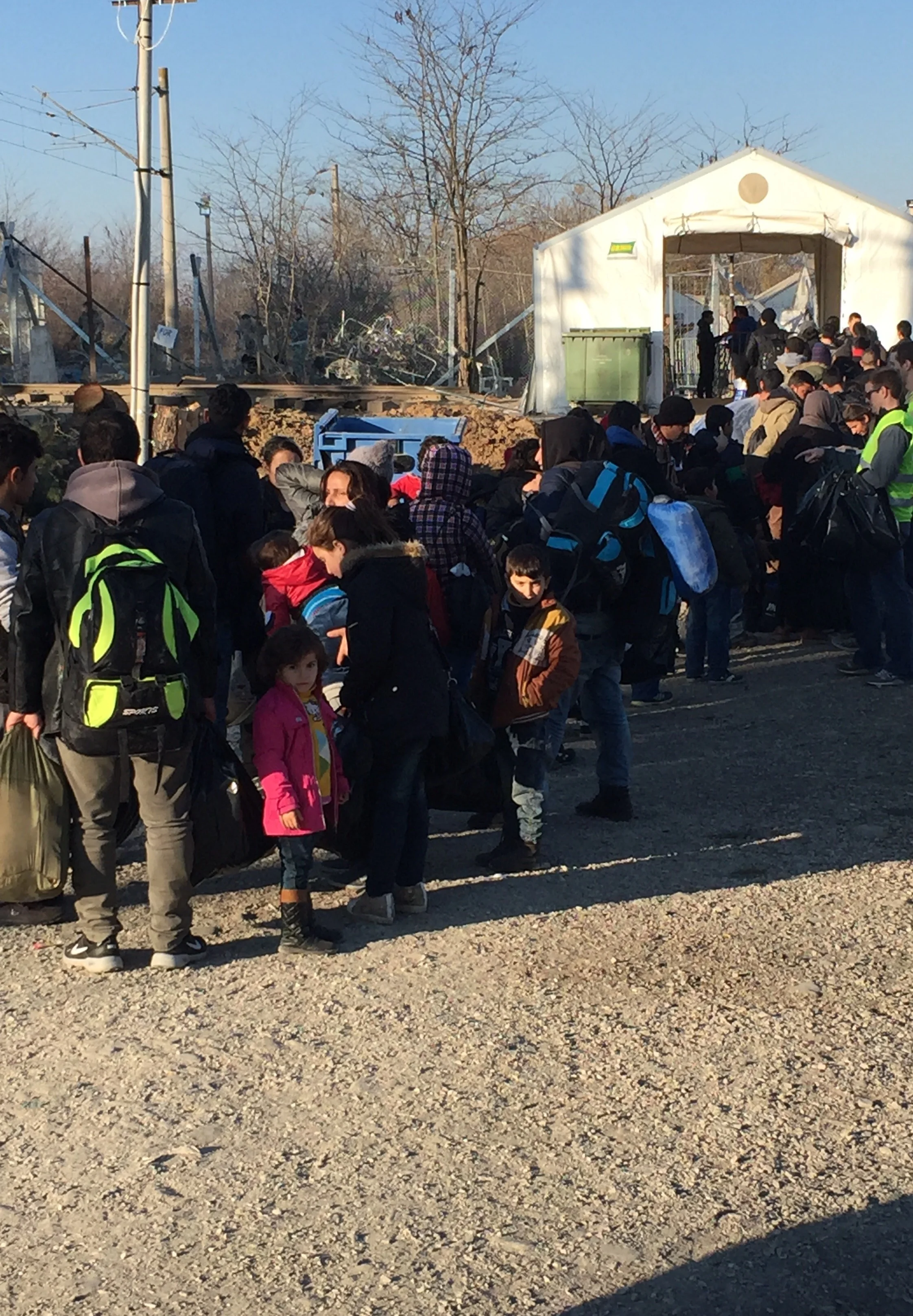 Handing out bags as the line to cross the border grows