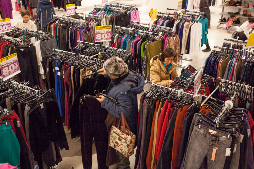  Customers rummage through heavily discounted clothing. 