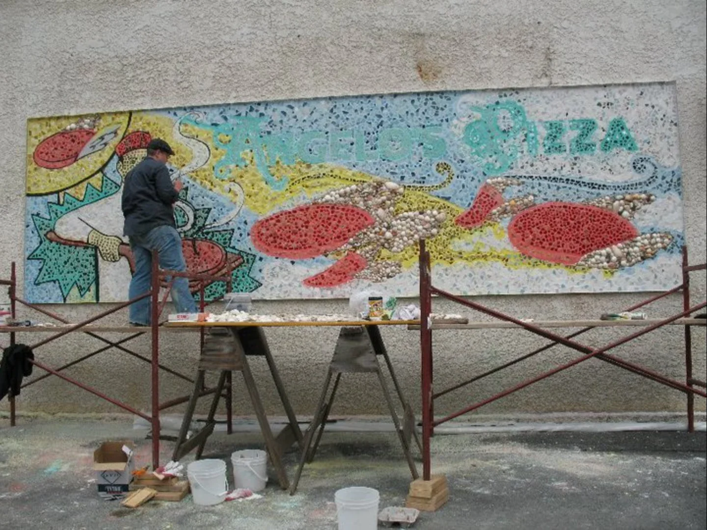  Painting the outline for the Angelo’s Pizza mosaic mural.  Photo by  Art for Auburn  