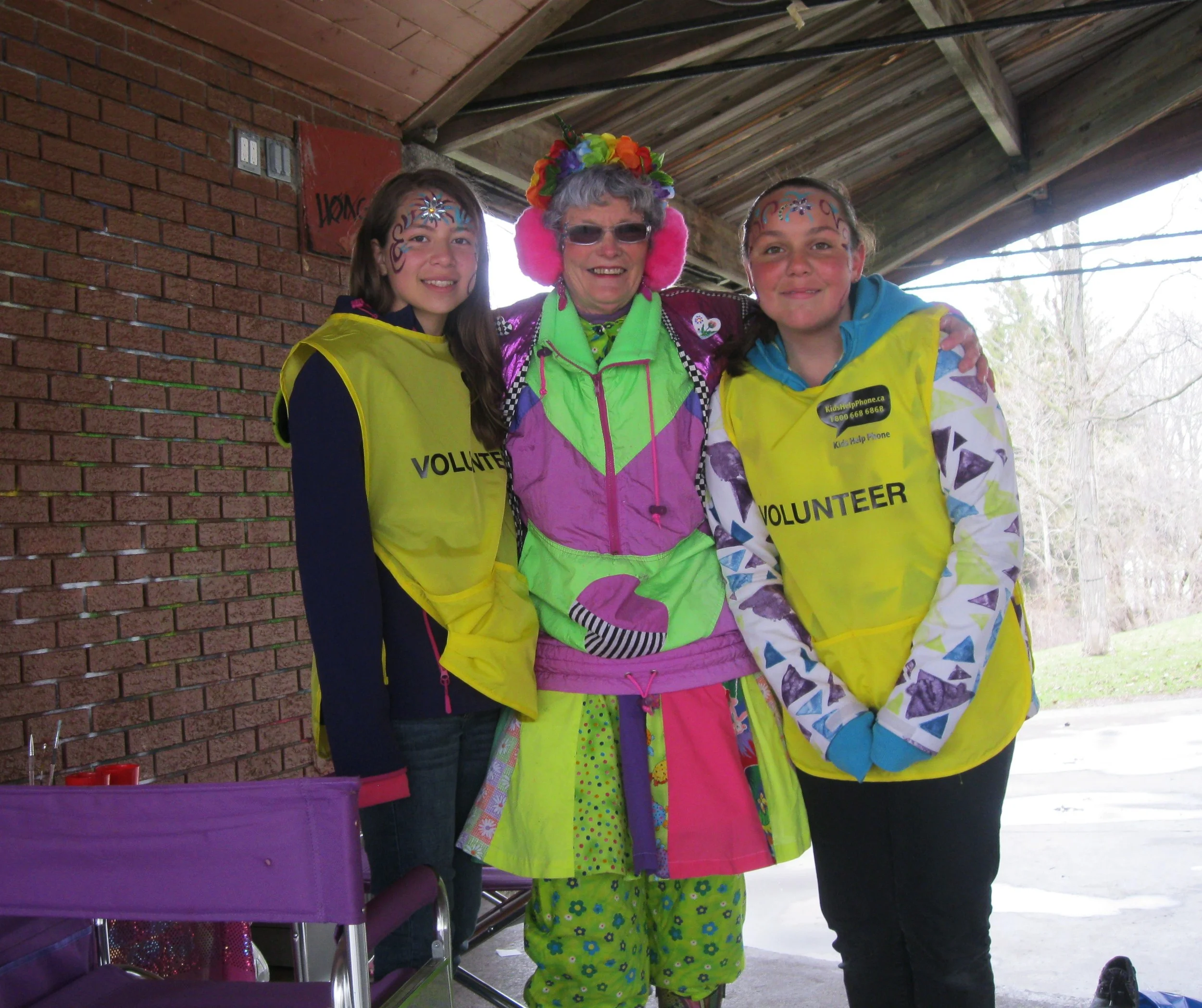 Sharon from Checkers Entertainment Services facepaints two high school walk volunteers