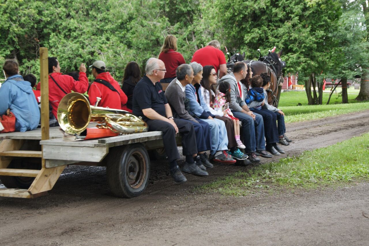 Tuba player Joe hitches a wagon ride at the 2015 Lang Pioneer Village Canada Day Celebration