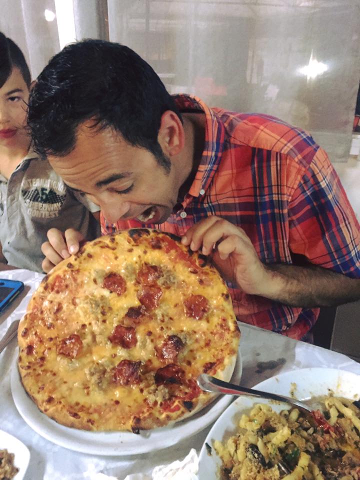 Adriano digs into a delicious pizza