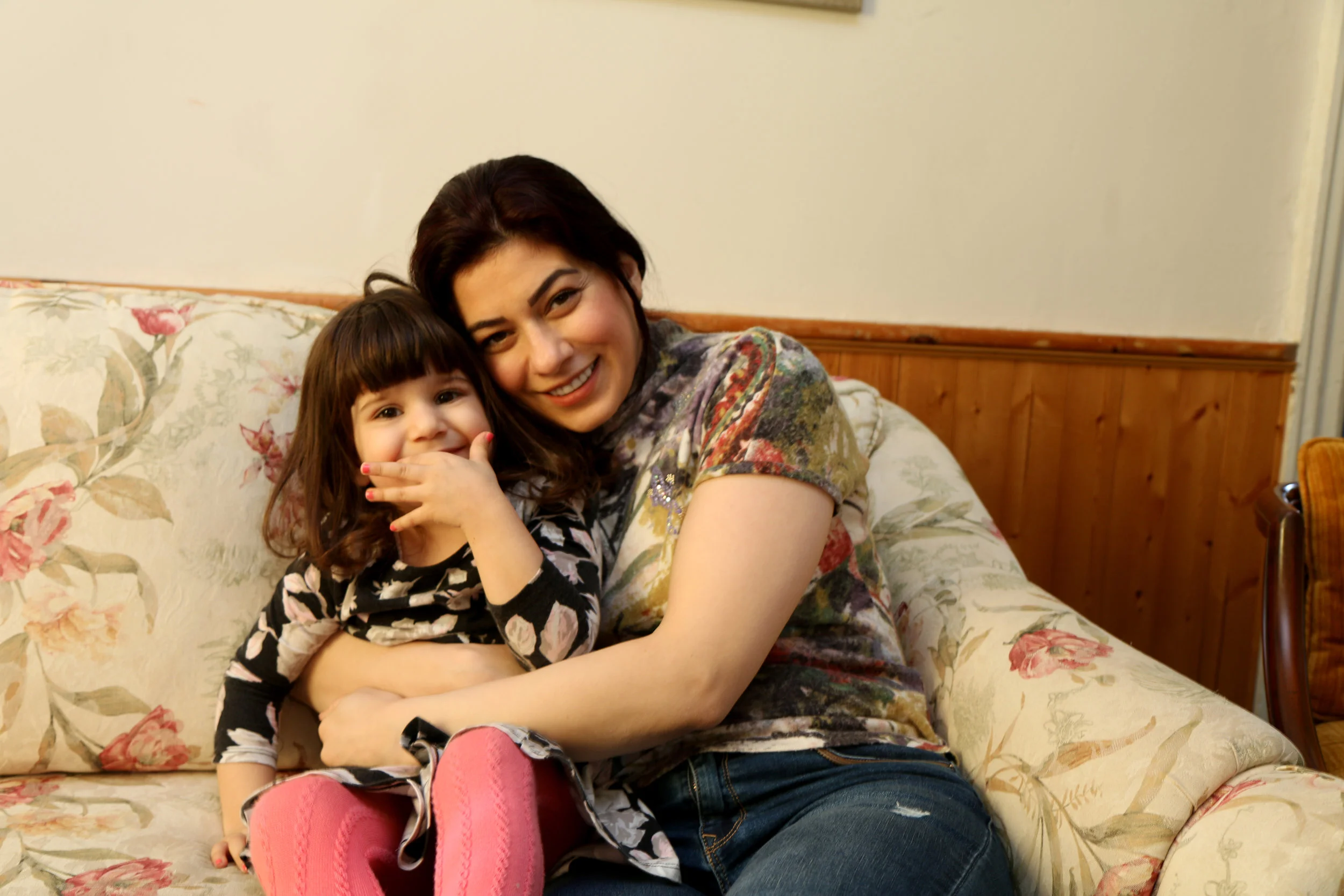 Nisrin and Selina share a laugh in the living room of their new home in Peterborough.