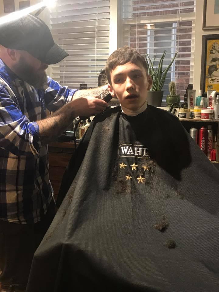 Stylist Adam Murray begins cutting Aidan's hair