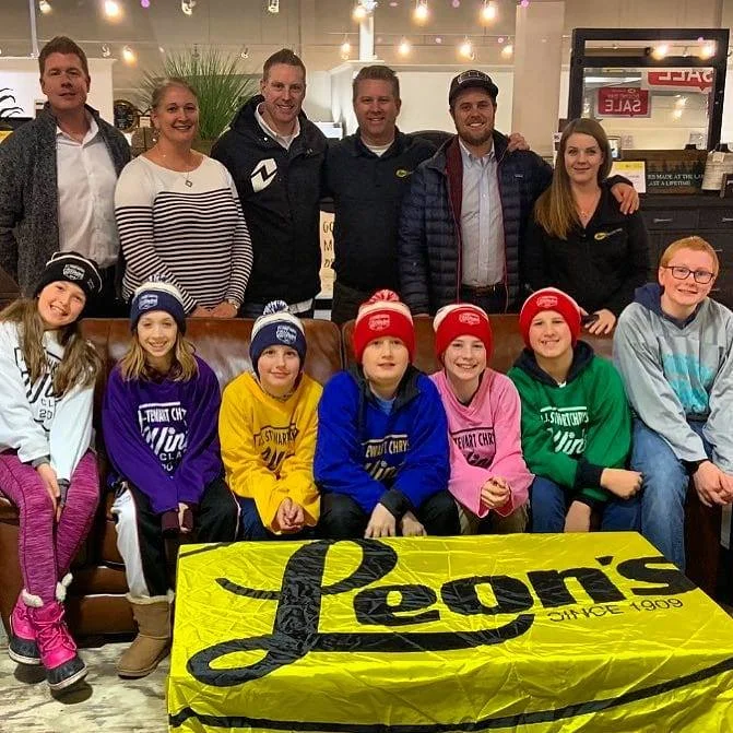 Players participating in 2019 JJ Stewart Chrysler Winter Classic. Front: Molly, Lili, Andrew, Liam, Carson, Sam and Logan. Back: Event Mascot Derek, Organizers Michelle, Mark, Aaron, Dani and Tom from Leon’s