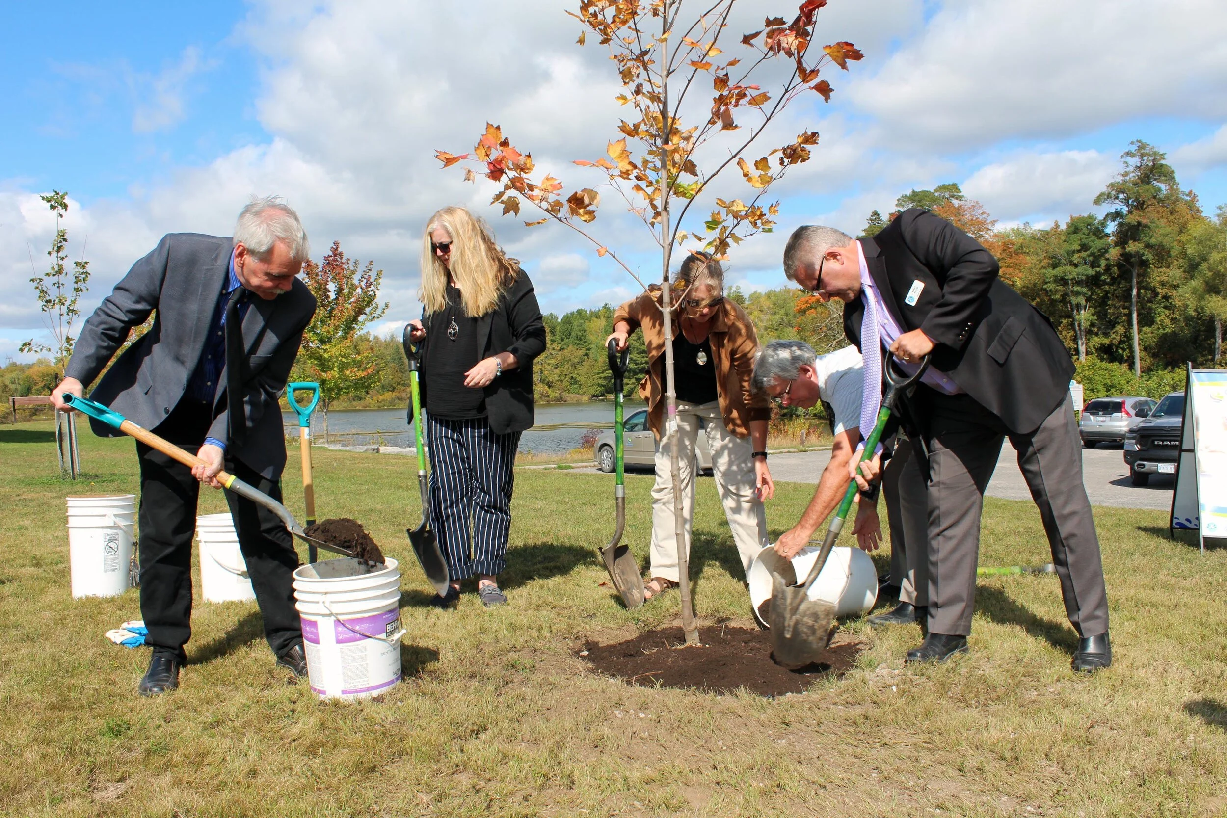Otonabee Conservation Board of Directors Chair, Andy Mitchell (left) shovels soil around a Northwood Red Maple tree, along with (left to right) Councillor Paula Warr, Deputy Mayor Lori Burtt, Mayor Roger Bonneau, and Councillor Barry Walsh, from Township of Asphodel-Norwood in Asphodel-Norwood. (photo courtesy otonabee conservation)