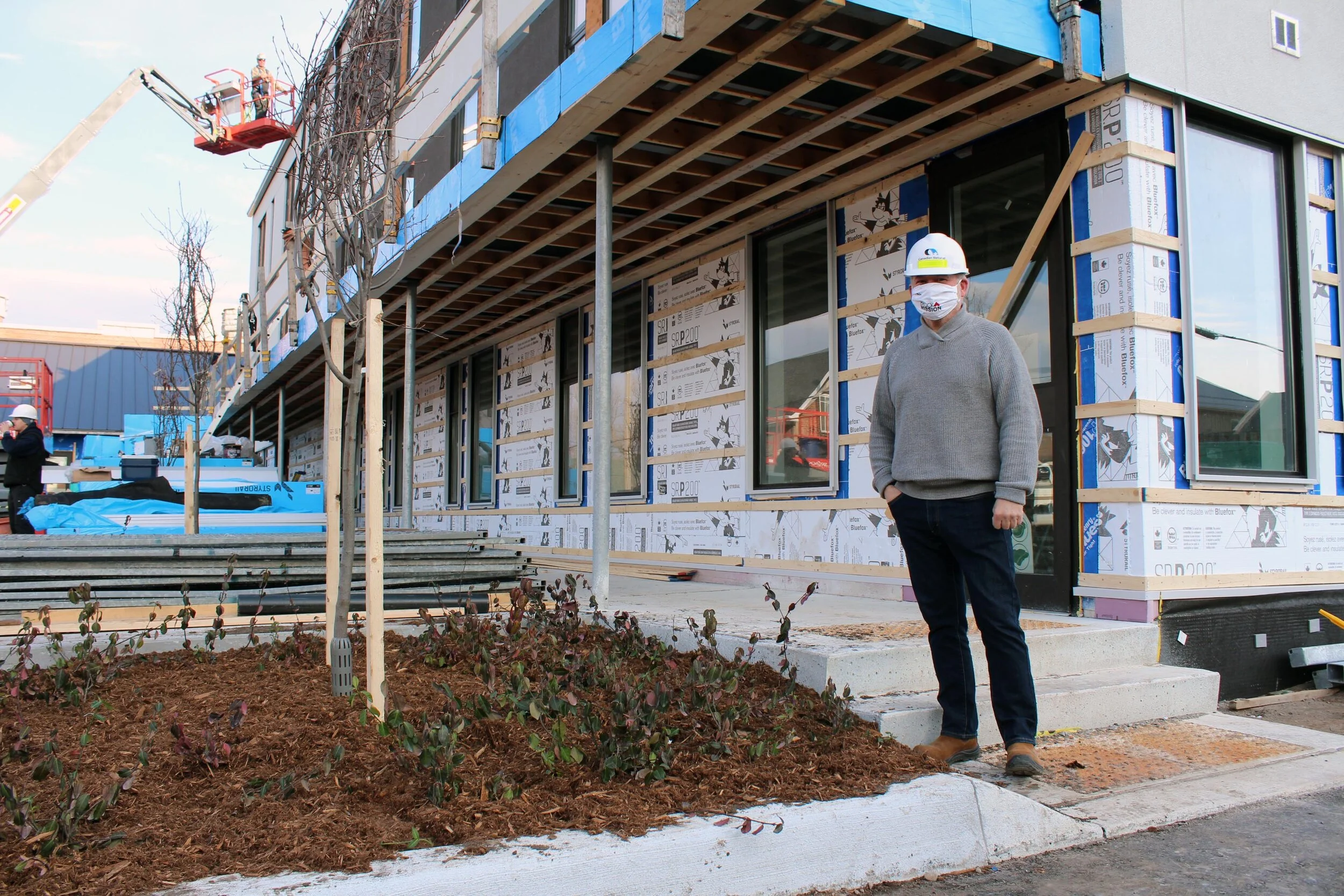 Bill McNabb, Executive Director of Brock Mission, stands next to a garden bed planted with fragrant sumac and spring flurry serviceberry at the build site for the new Brock Mission men’s shelter (Photo courtesy Otonabee Conservation)