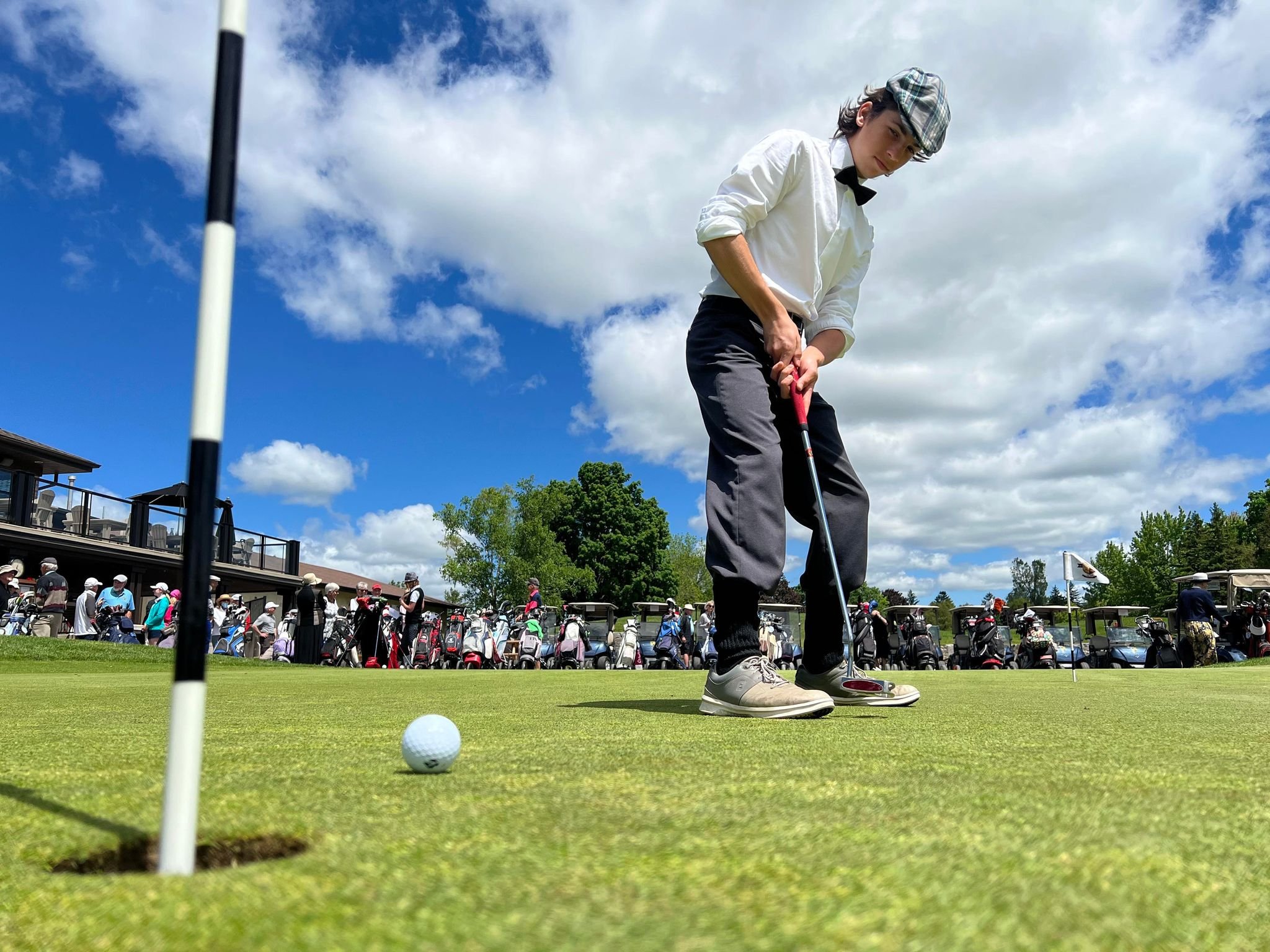  St. Peter’s Secondary School student Josh Watson, 14, warms up with a putt prior to the tournament. Photo by David Tuan Bui. 